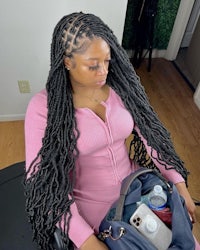 a woman with long dreadlocks sitting in a chair